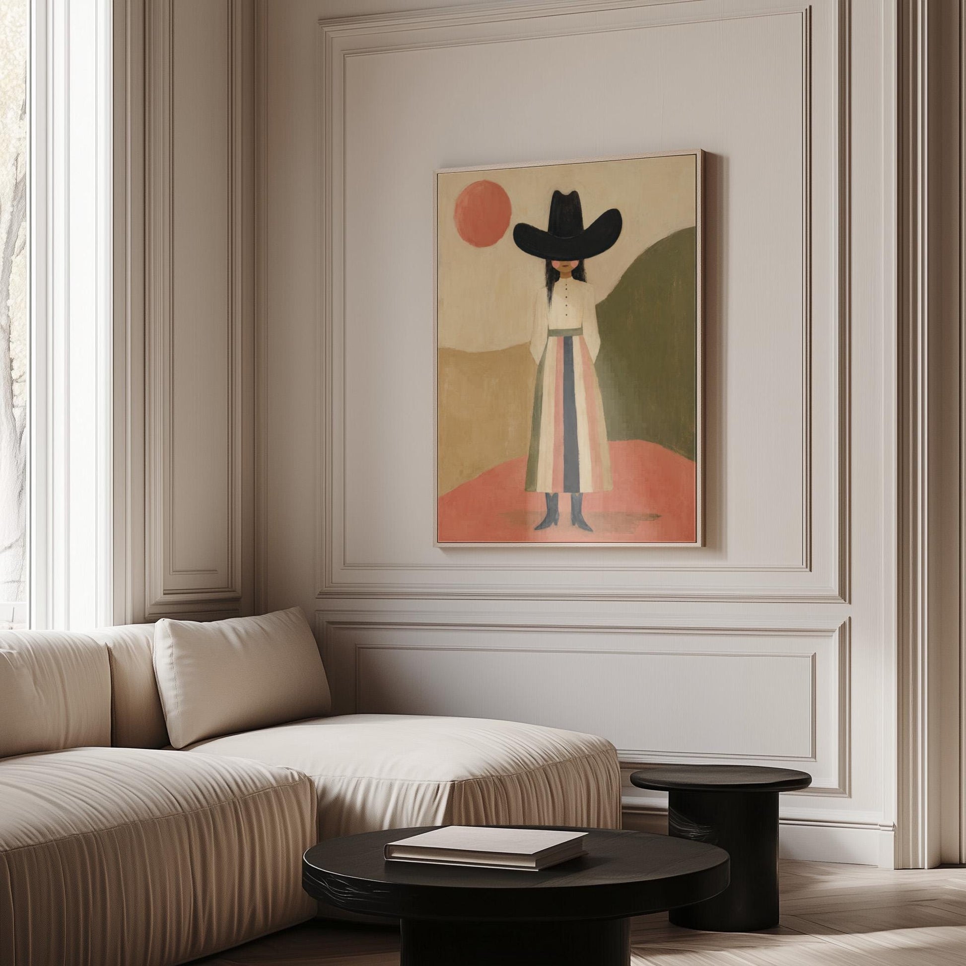 Figure in black cowboy hat standing between coral desert hills, canvas print displayed on a neutral wall in a styled interior
