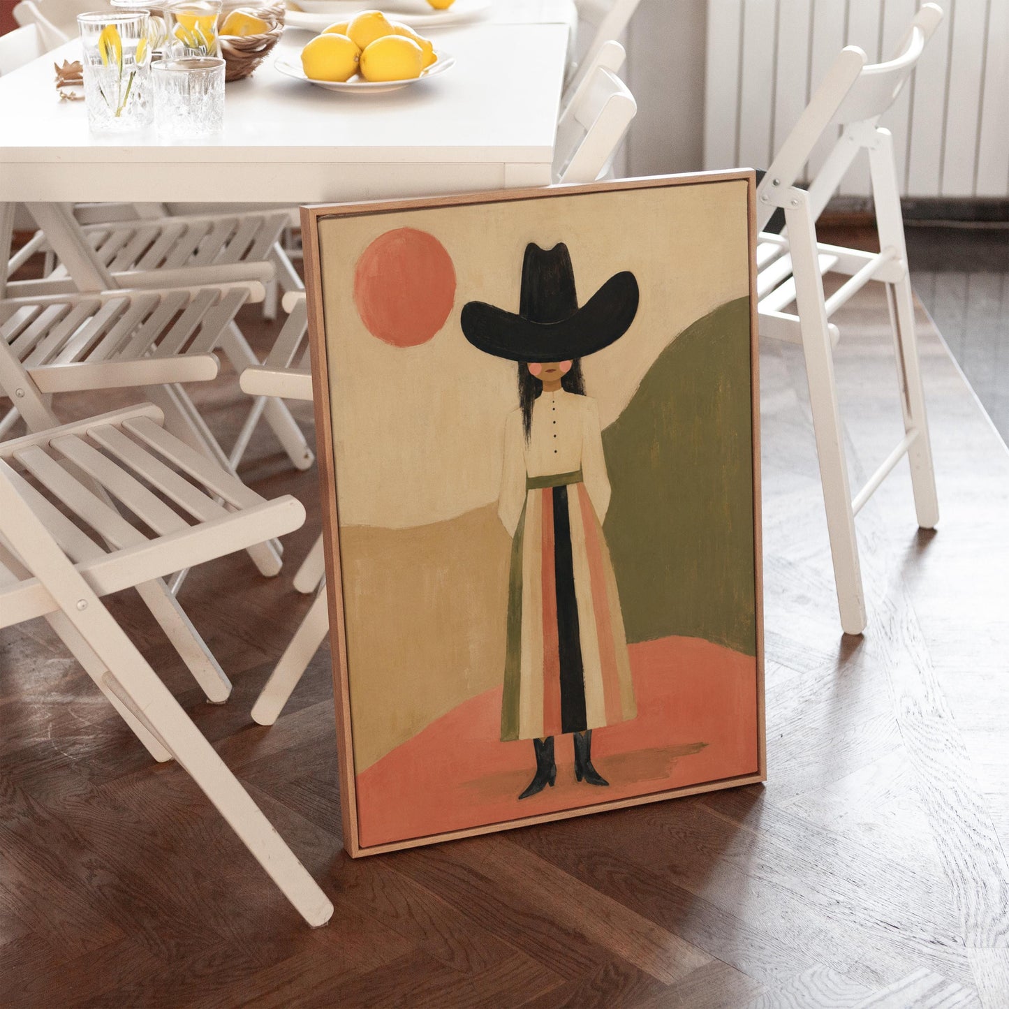 Figure in black cowboy hat standing between coral desert hills, canvas wall art on a quiet wall in a considered interior