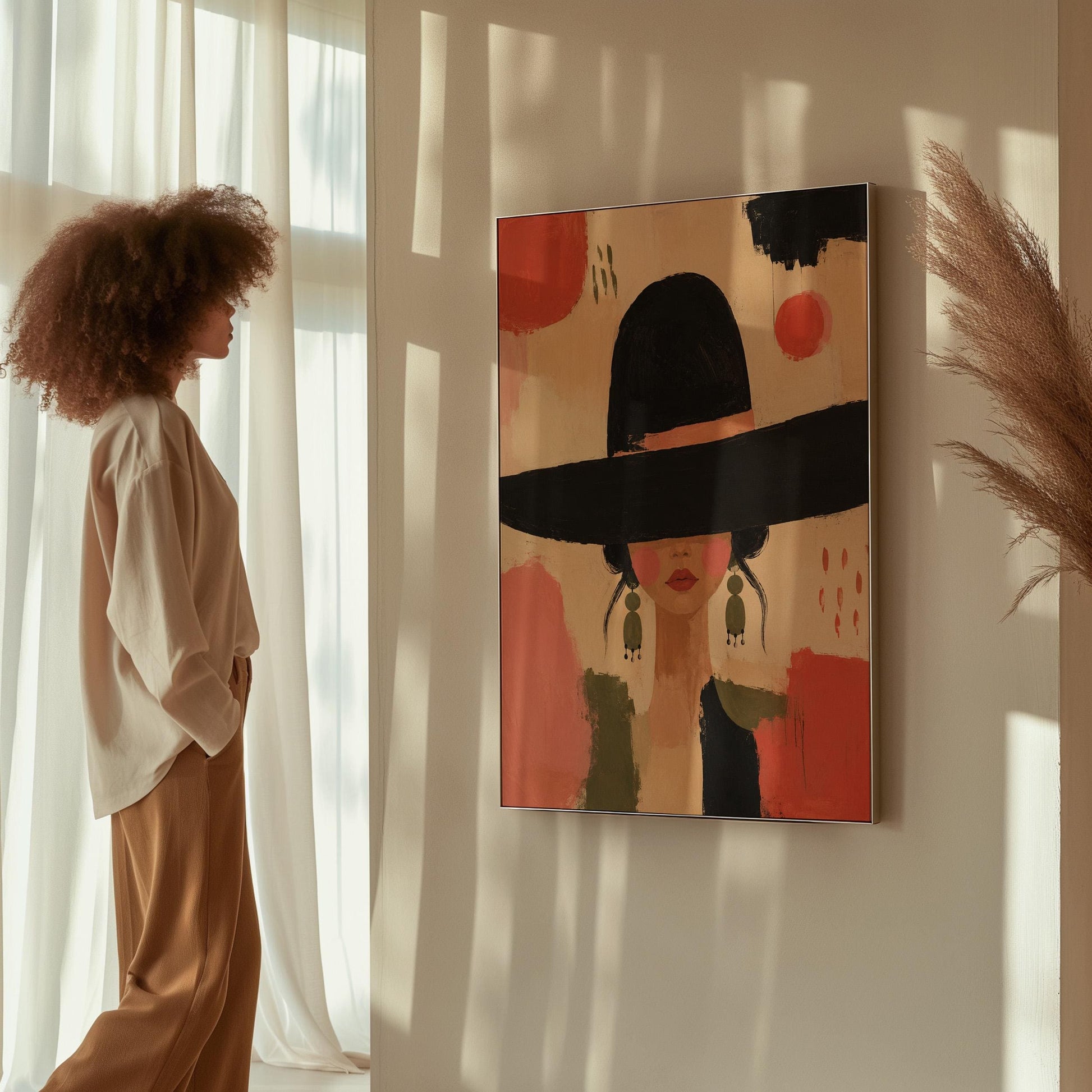 Woman in a wide black hat with olive earrings on red brushwork, canvas print seen in a warm interior with natural light