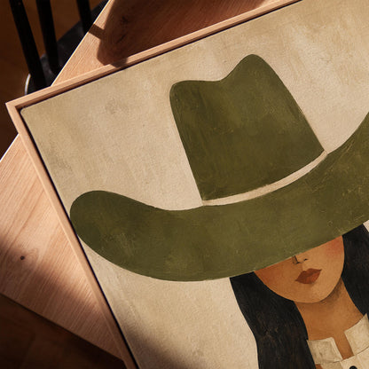Cowgirl in olive hat and striped western shirt on sandy beige, canvas print in a warm, minimally styled interior