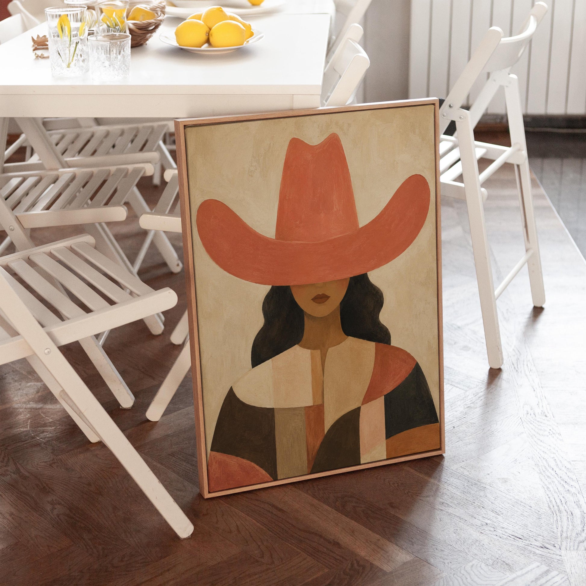 Cowgirl in a broad terracotta hat and patchwork western shirt, canvas print on a quiet wall in a considered interior