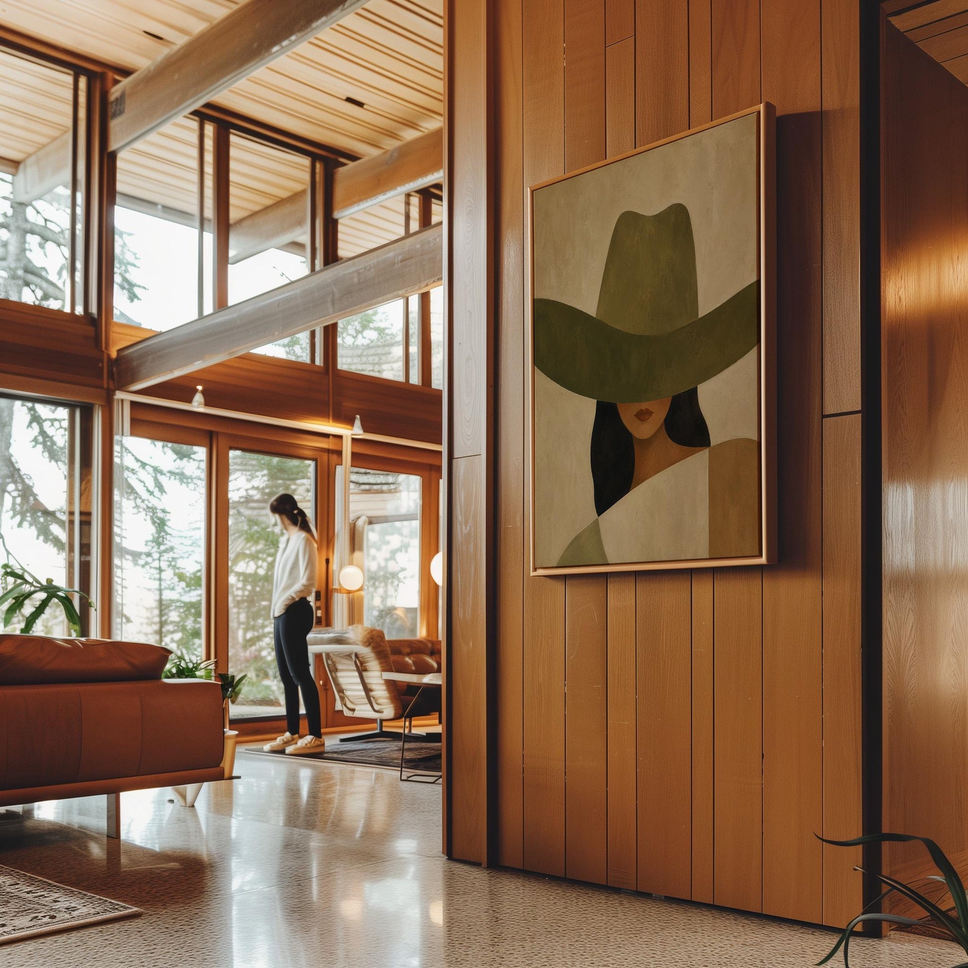 Cropped cowgirl face beneath the sweeping brim of a large olive hat, canvas wall art on a quiet wall in a considered interior