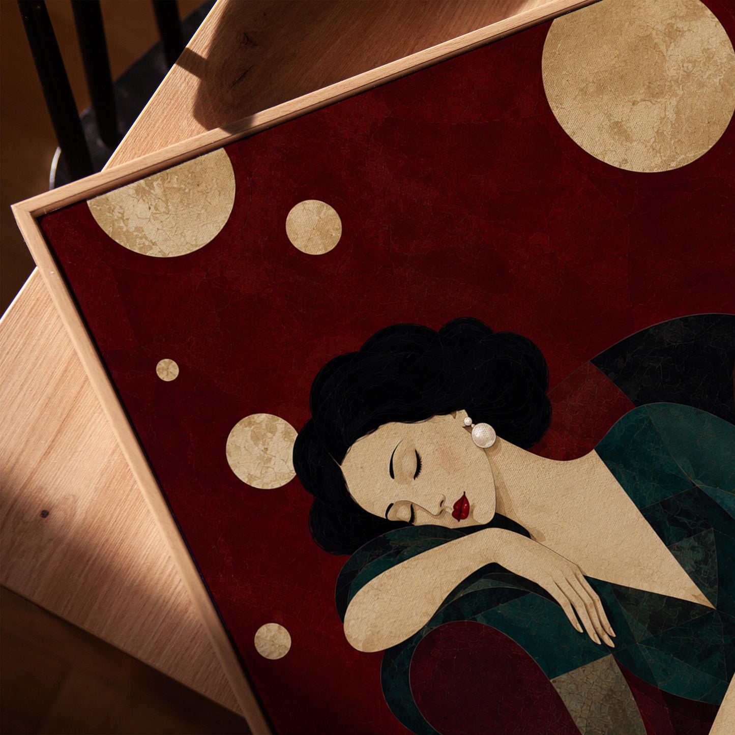 Dark haired woman asleep draped over the back of a deep red armchair, canvas print in a warm, minimally styled interior