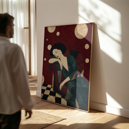 Dark haired woman asleep draped over the back of a deep red armchair, canvas print displayed on a neutral wall in a styled interior