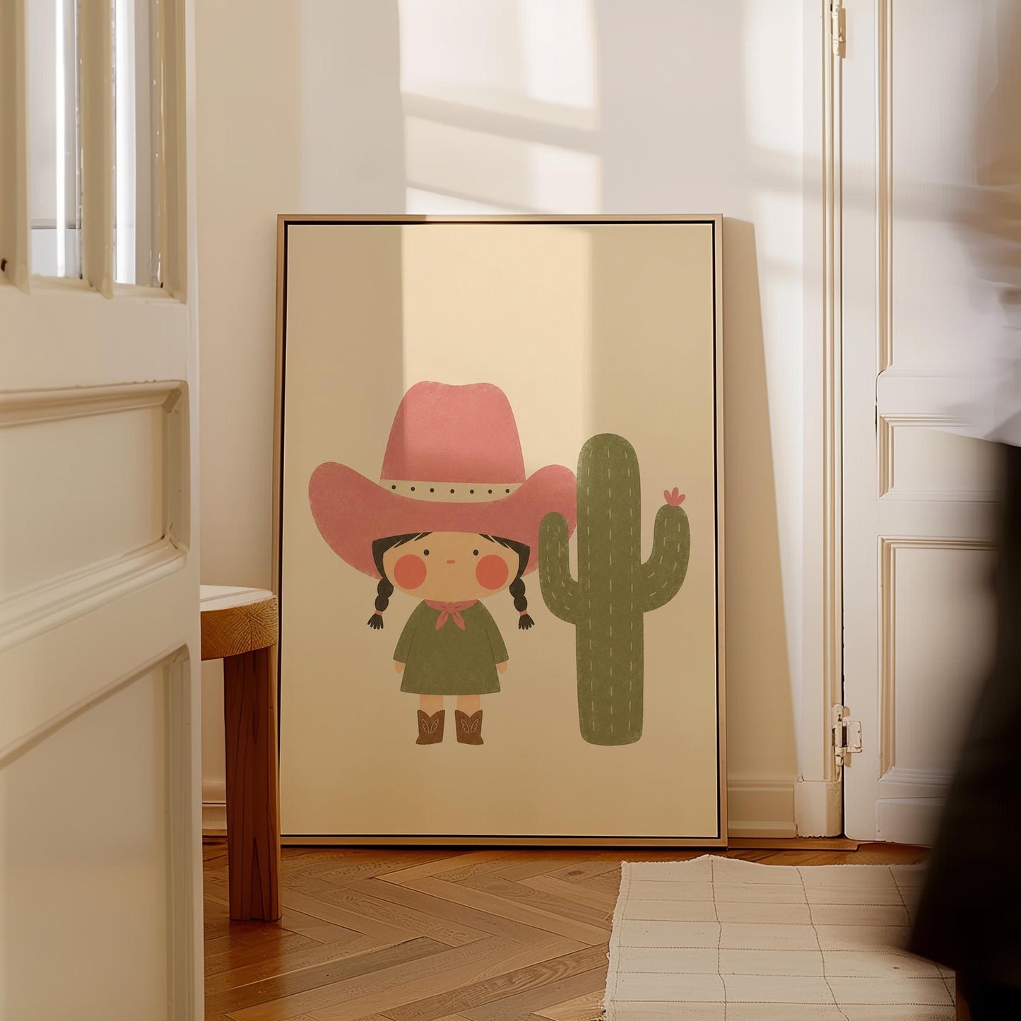 Little cowgirl in a pink hat next to a tall flowering cactus, canvas print seen in a warm interior with natural light