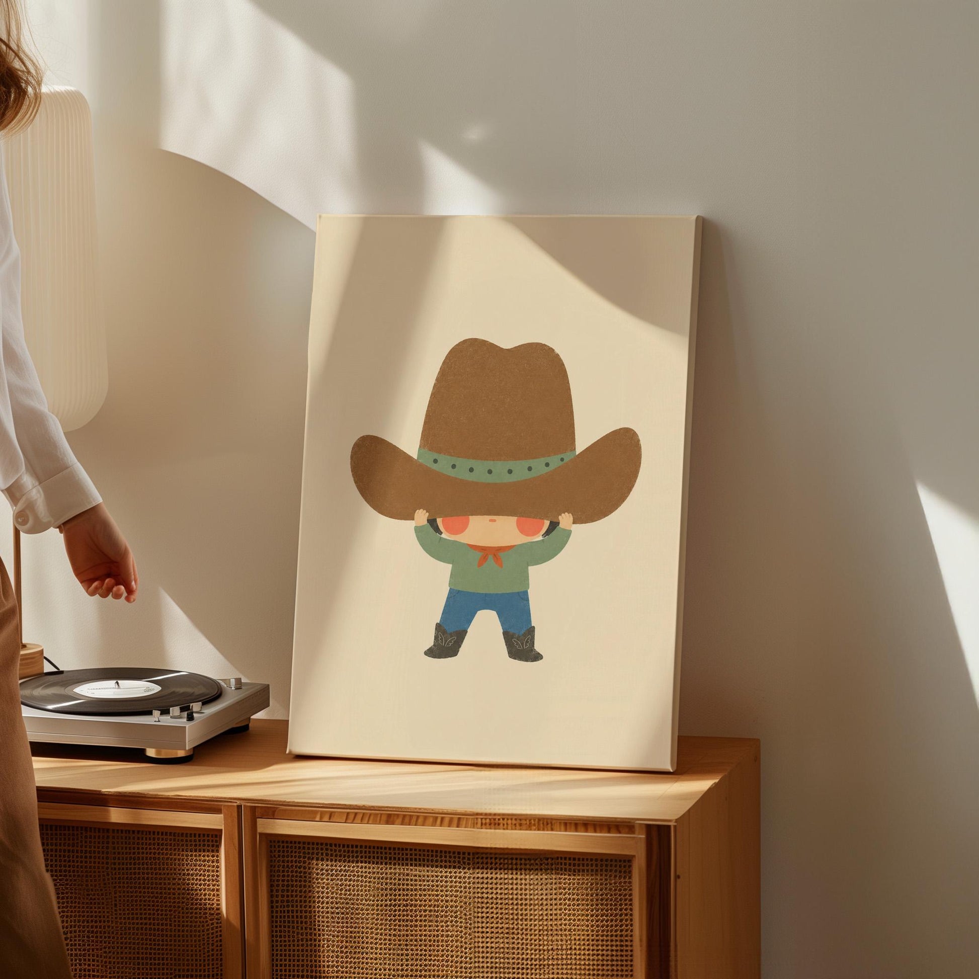 Child lifting an enormous brown cowboy hat above their eyes, canvas wall art styled against a soft white wall