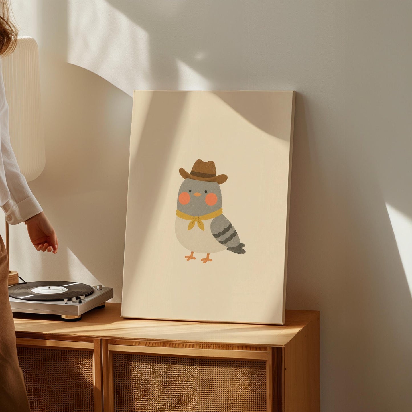 Round grey bird wearing a tiny cowboy hat and yellow bandana, canvas print shown to scale in a furnished room