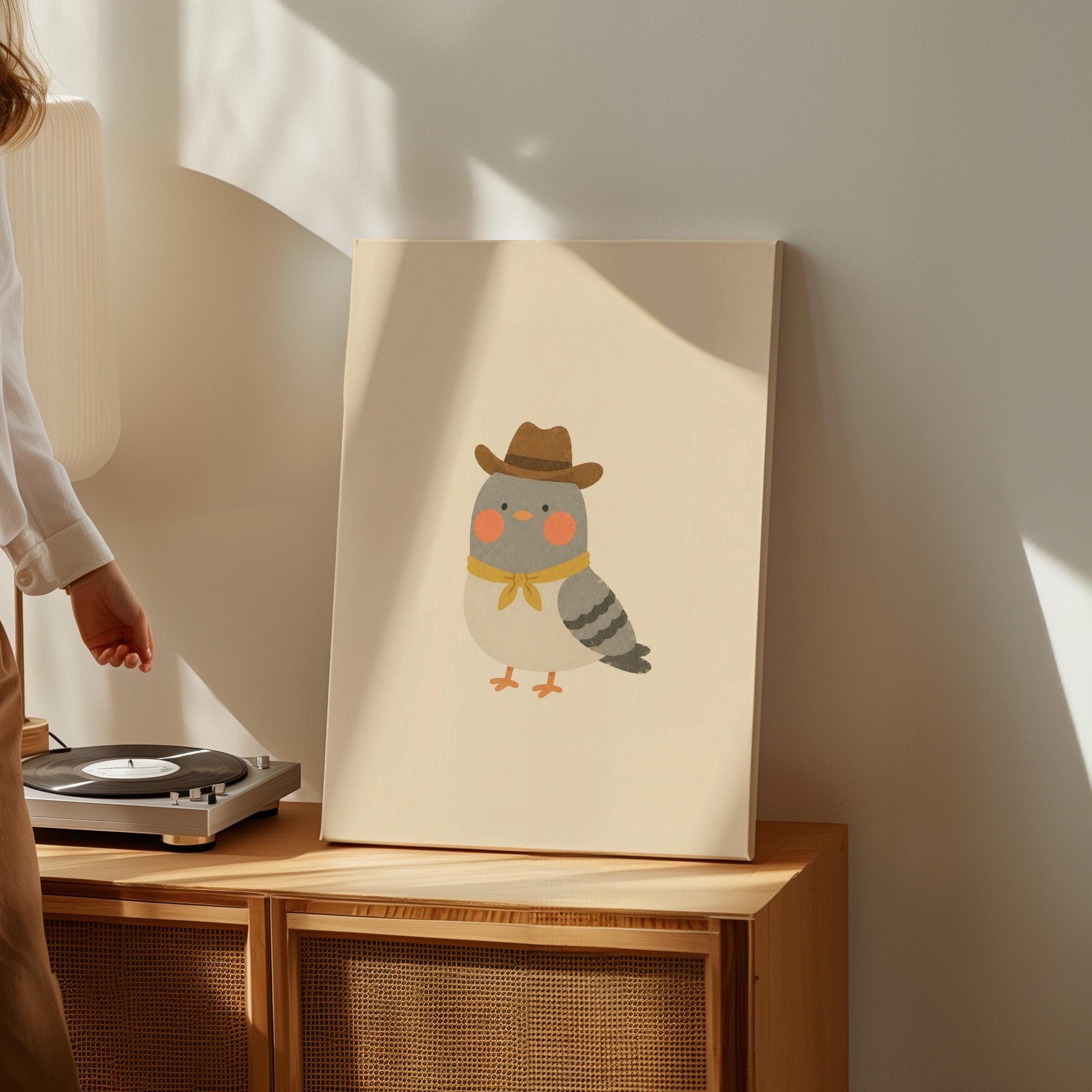 Round grey bird wearing a tiny cowboy hat and yellow bandana, canvas print shown to scale in a furnished room