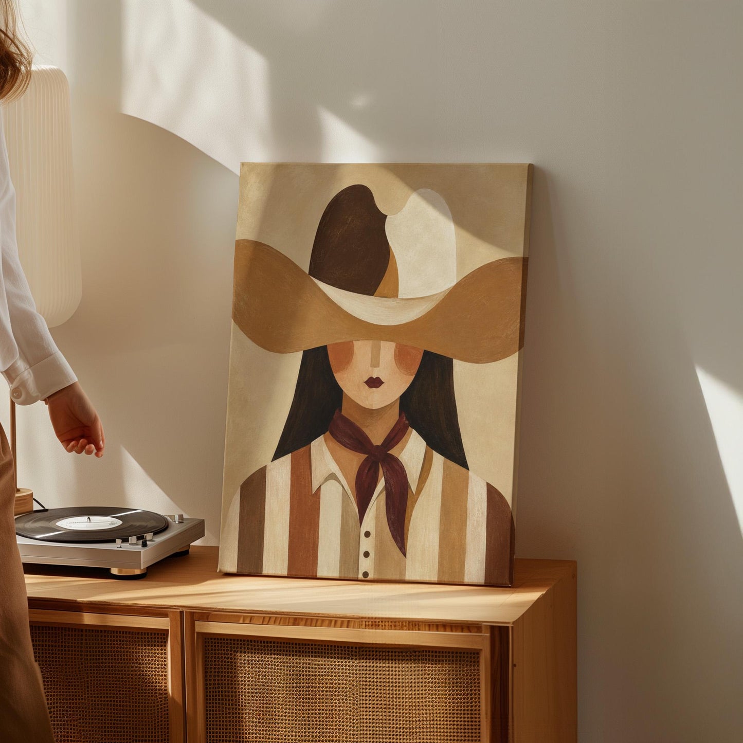 Cowgirl in a sweeping two-tone hat with a burgundy neckerchief, canvas wall art presented in a light, minimal room