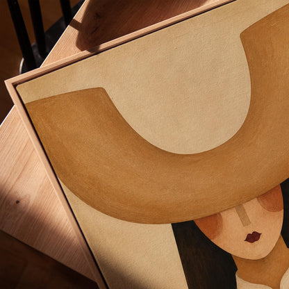 Faceless cowgirl under an enormous curved tan cowboy hat brim shape, canvas print in a warm, minimally styled interior
