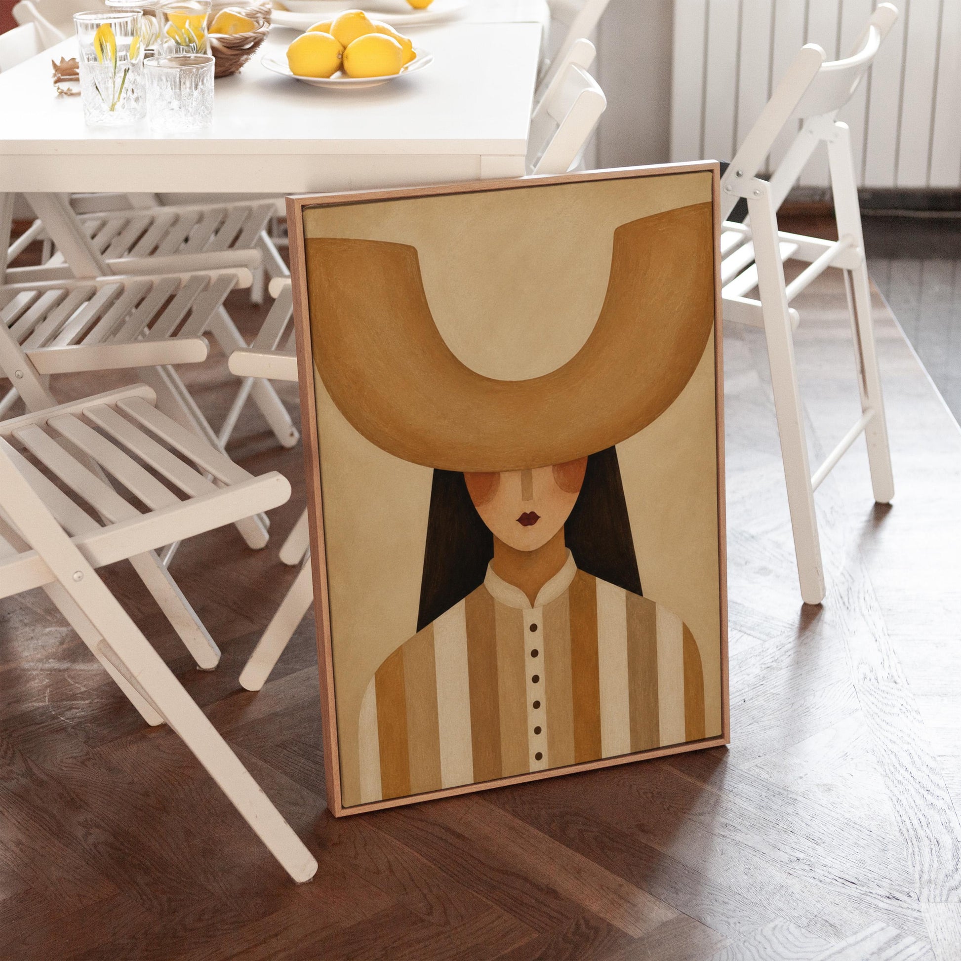 Faceless cowgirl under an enormous curved tan cowboy hat brim shape, canvas print shown in a sunlit, contemporary room