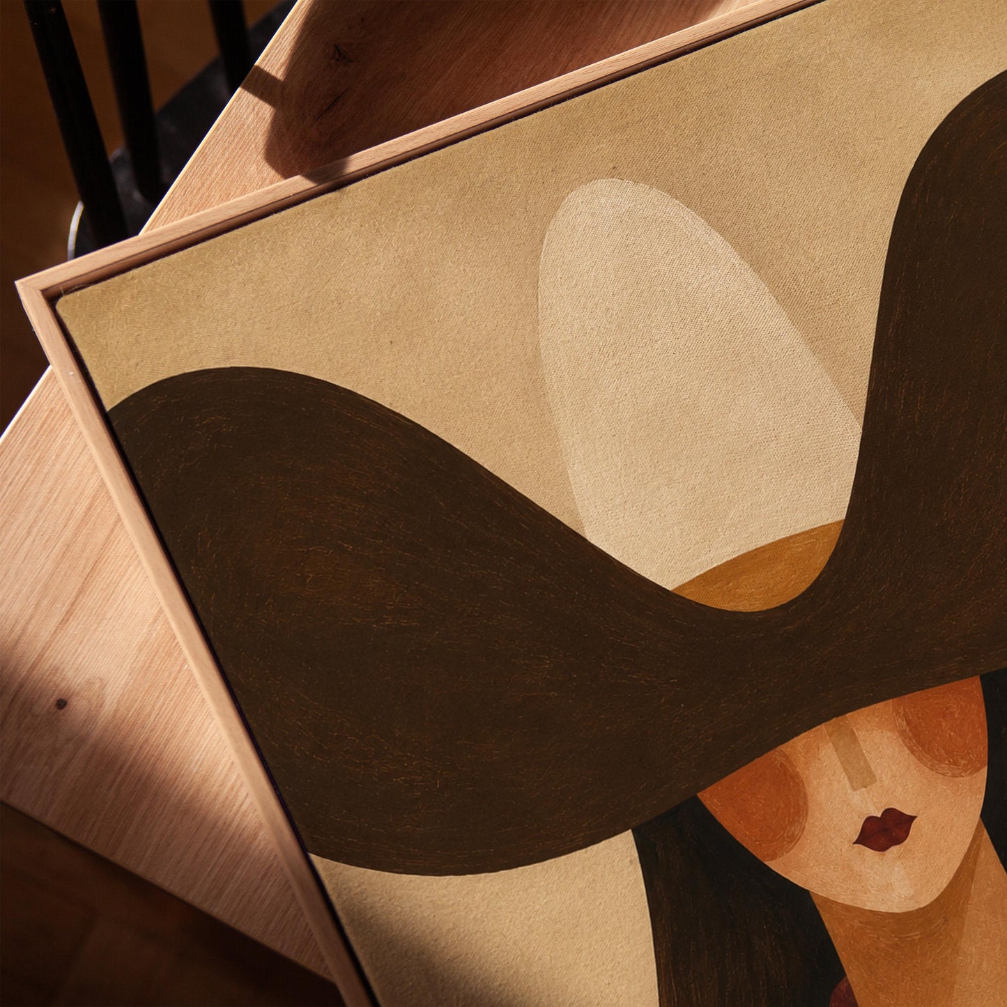Faceless cowgirl in a wide black hat and mauve neckerchief on tan background, canvas print in a warm, minimally styled interior