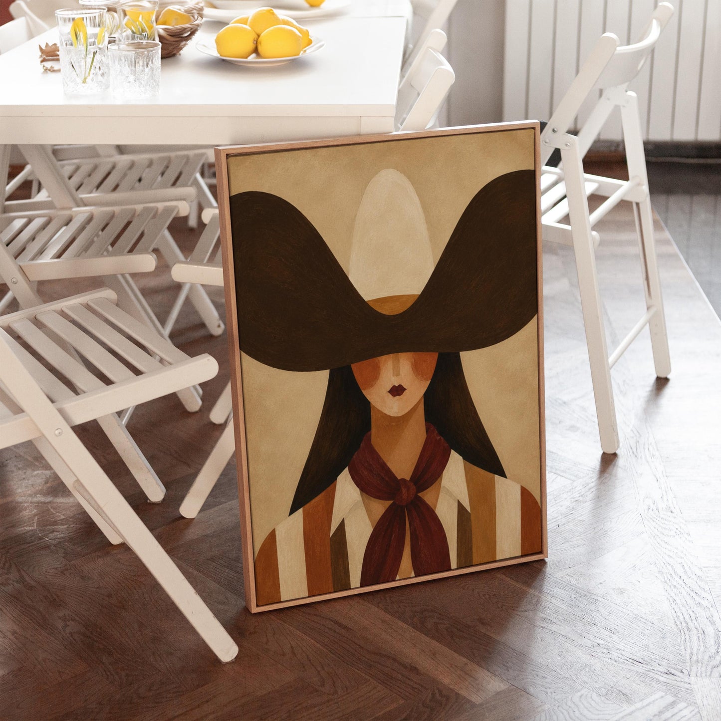 Faceless cowgirl in a wide black hat and mauve neckerchief on tan background, canvas print seen in a warm interior with natural light