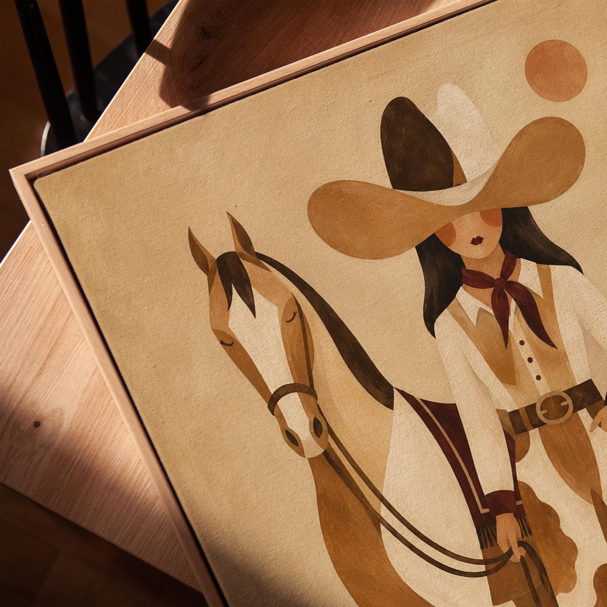 Cowgirl in cow print chaps standing beside a horse in a warm desert scene, canvas print in a warm, minimally styled interior