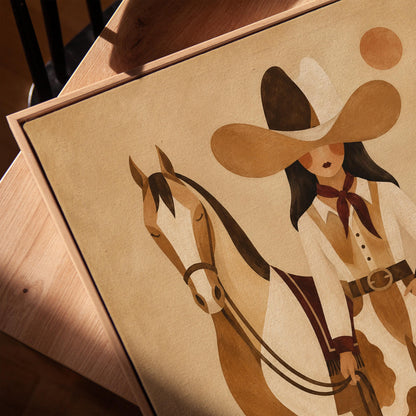 Cowgirl in cow print chaps standing beside a horse in a warm desert scene, canvas print in a warm, minimally styled interior