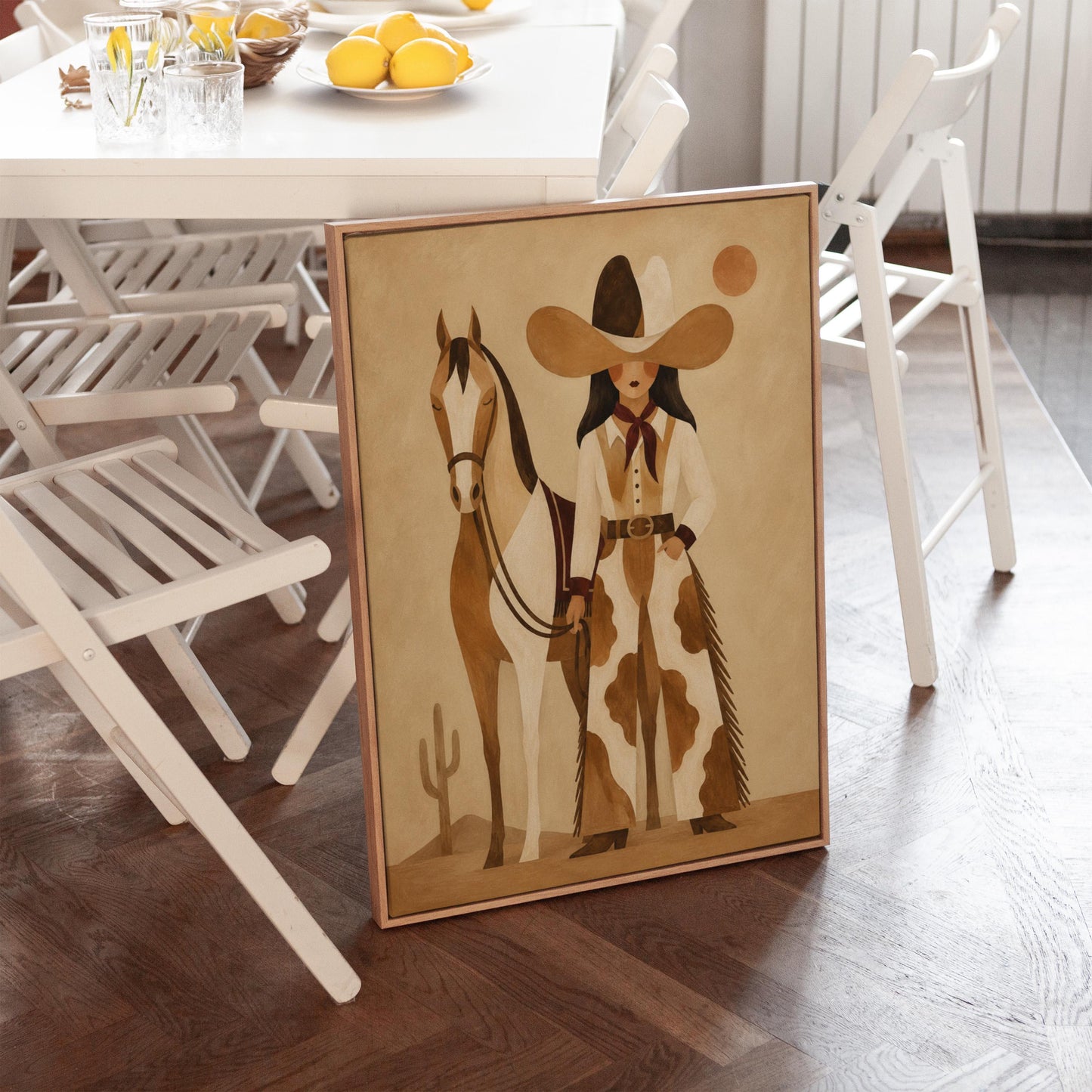 Cowgirl in cow print chaps standing beside a horse in a warm desert scene, canvas wall art hanging in a calm, modern living space