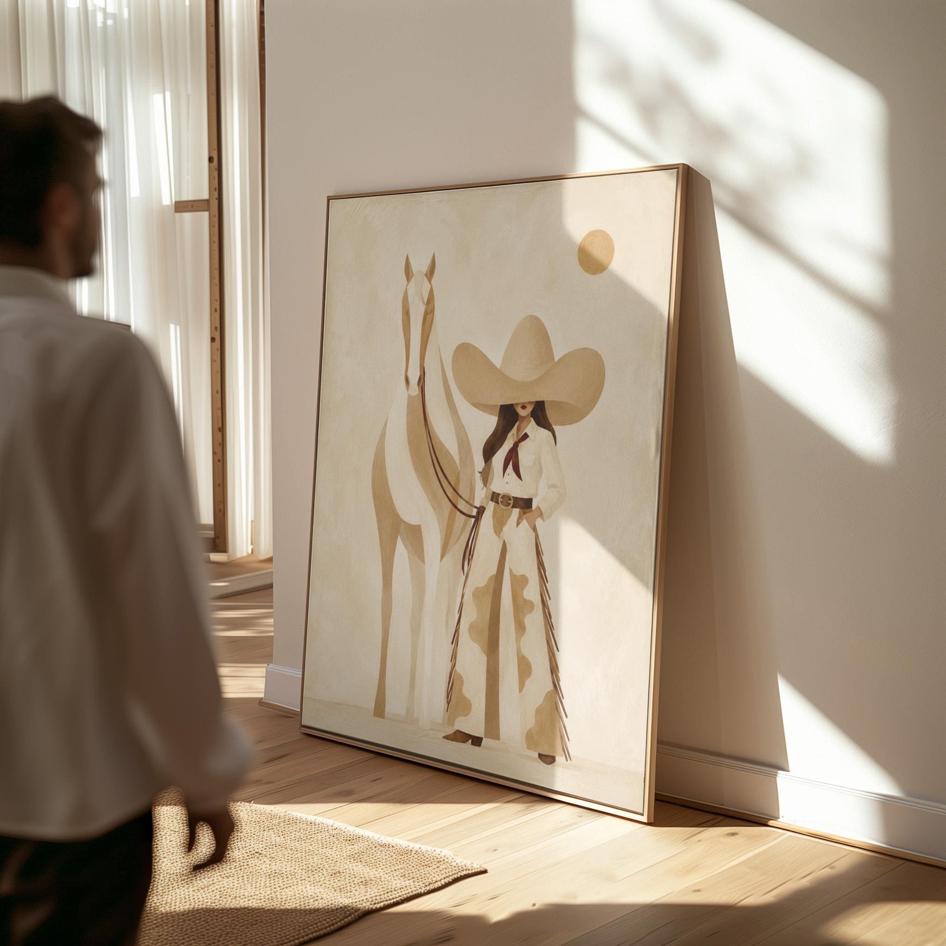 Cowgirl in cream chaps beside a pale horse under a small ochre sun, canvas print shown to scale in a furnished room