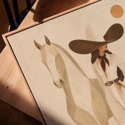 Cowgirl in a dark hat with a pale horse before soft desert hills, canvas print in a warm, minimally styled interior