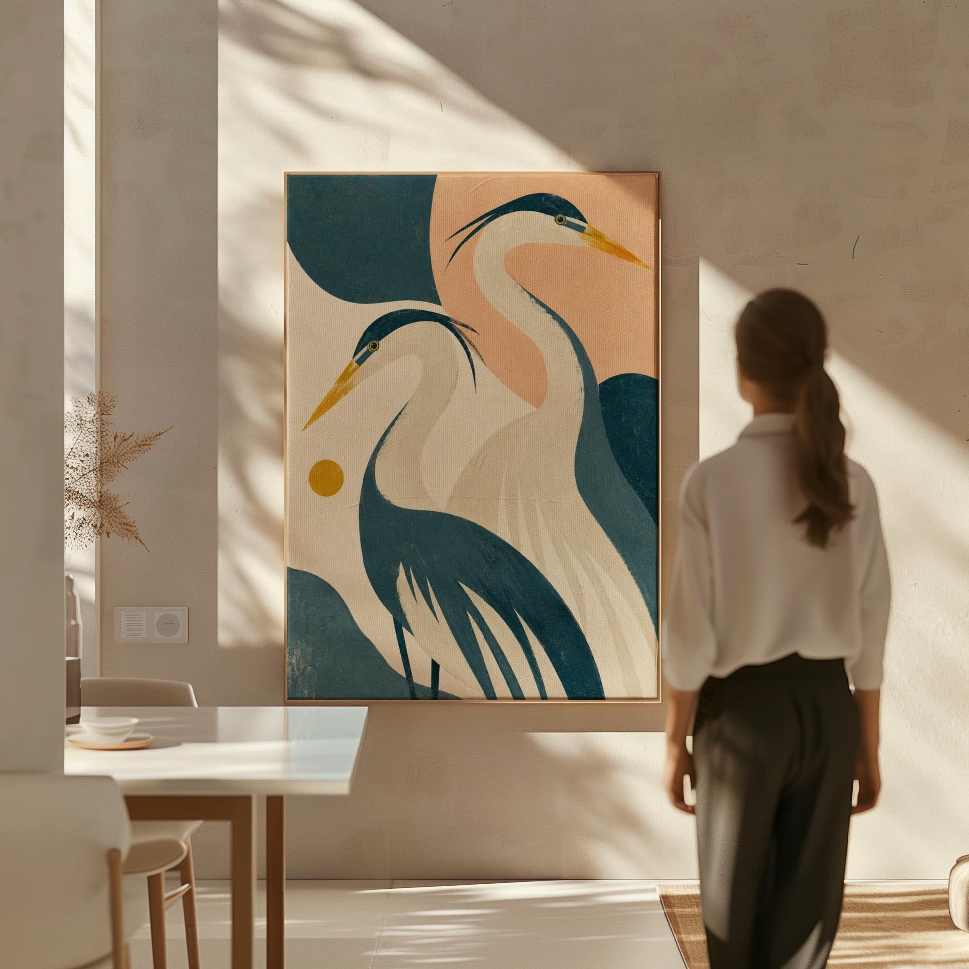 Two great herons with yellow beaks against a peach and teal sky, canvas wall art styled against a soft white wall