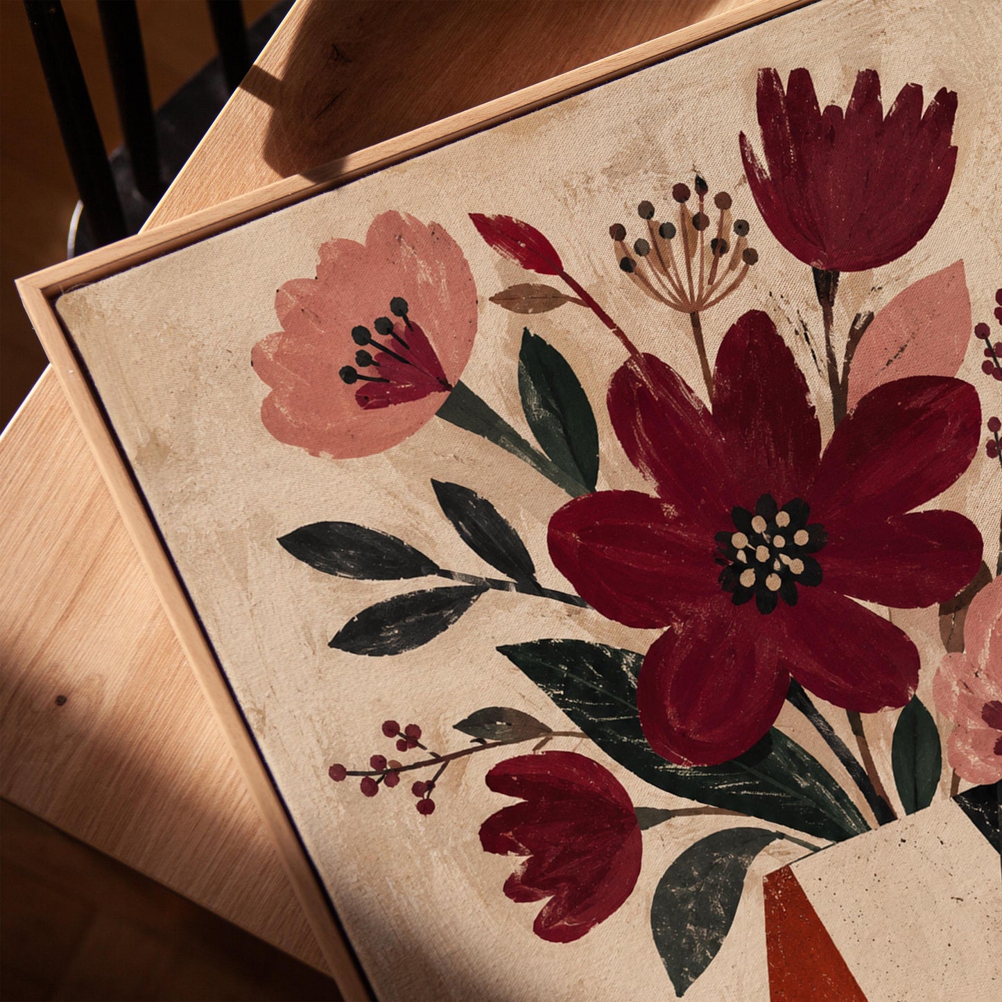 Burgundy and dusty pink flowers in a striped vase on a striped table, canvas print in a warm, minimally styled interior