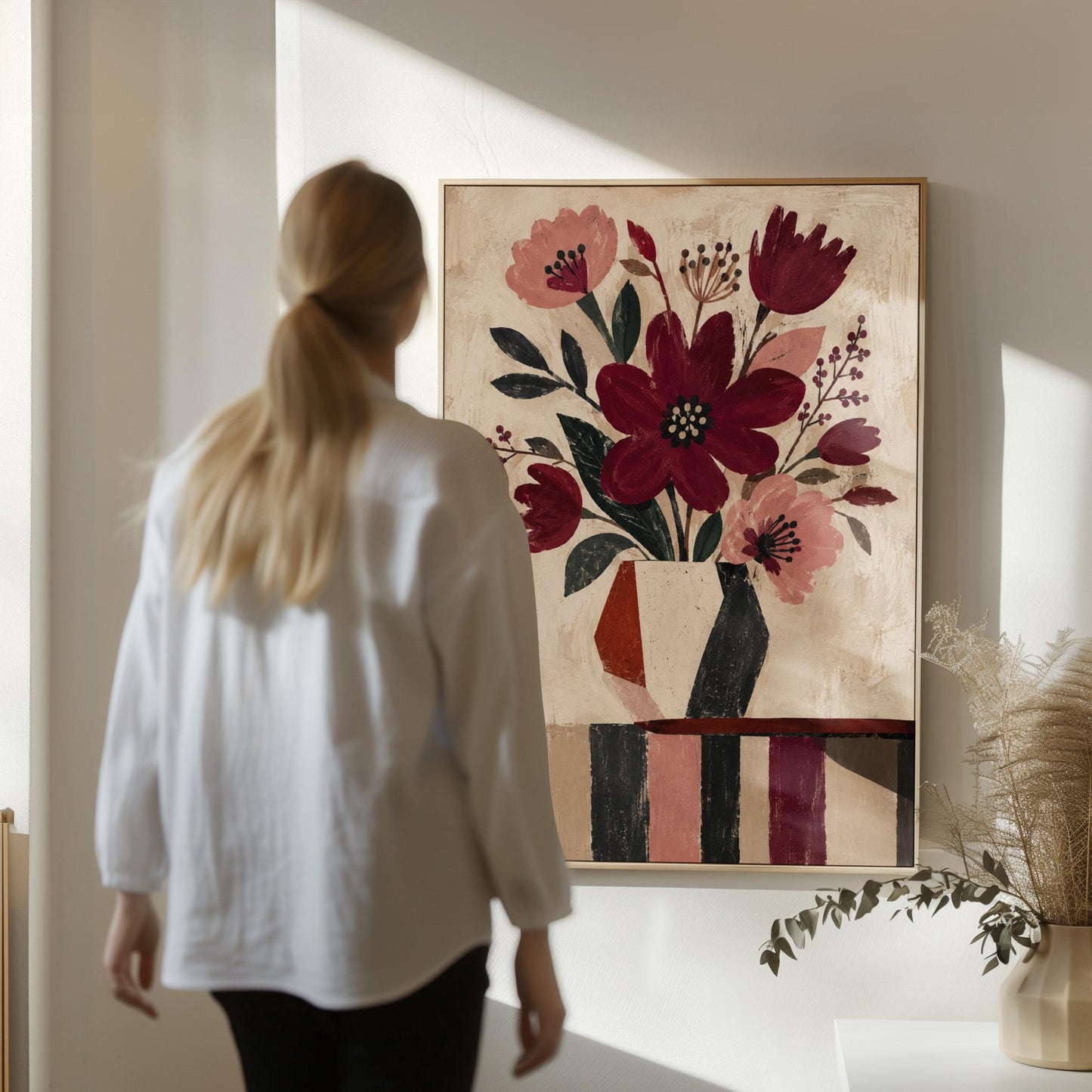 Burgundy and dusty pink flowers in a striped vase on a striped table, canvas print presented in a light, minimal room