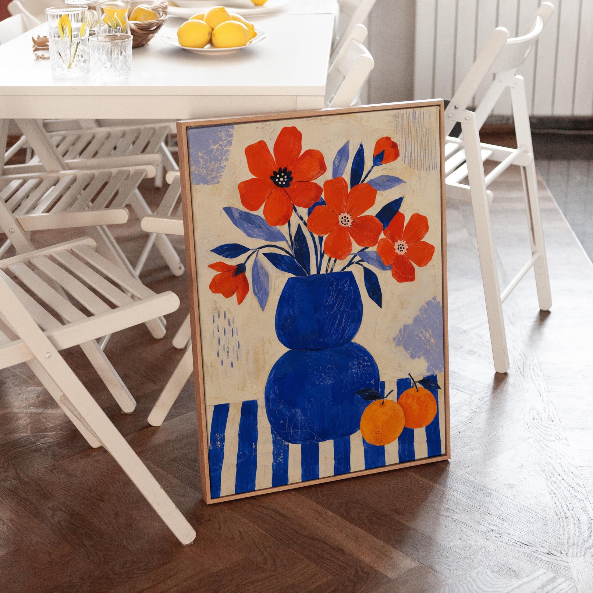 Scarlet poppies in a cobalt vase with oranges on a blue striped cloth, canvas print shown to scale in a furnished room