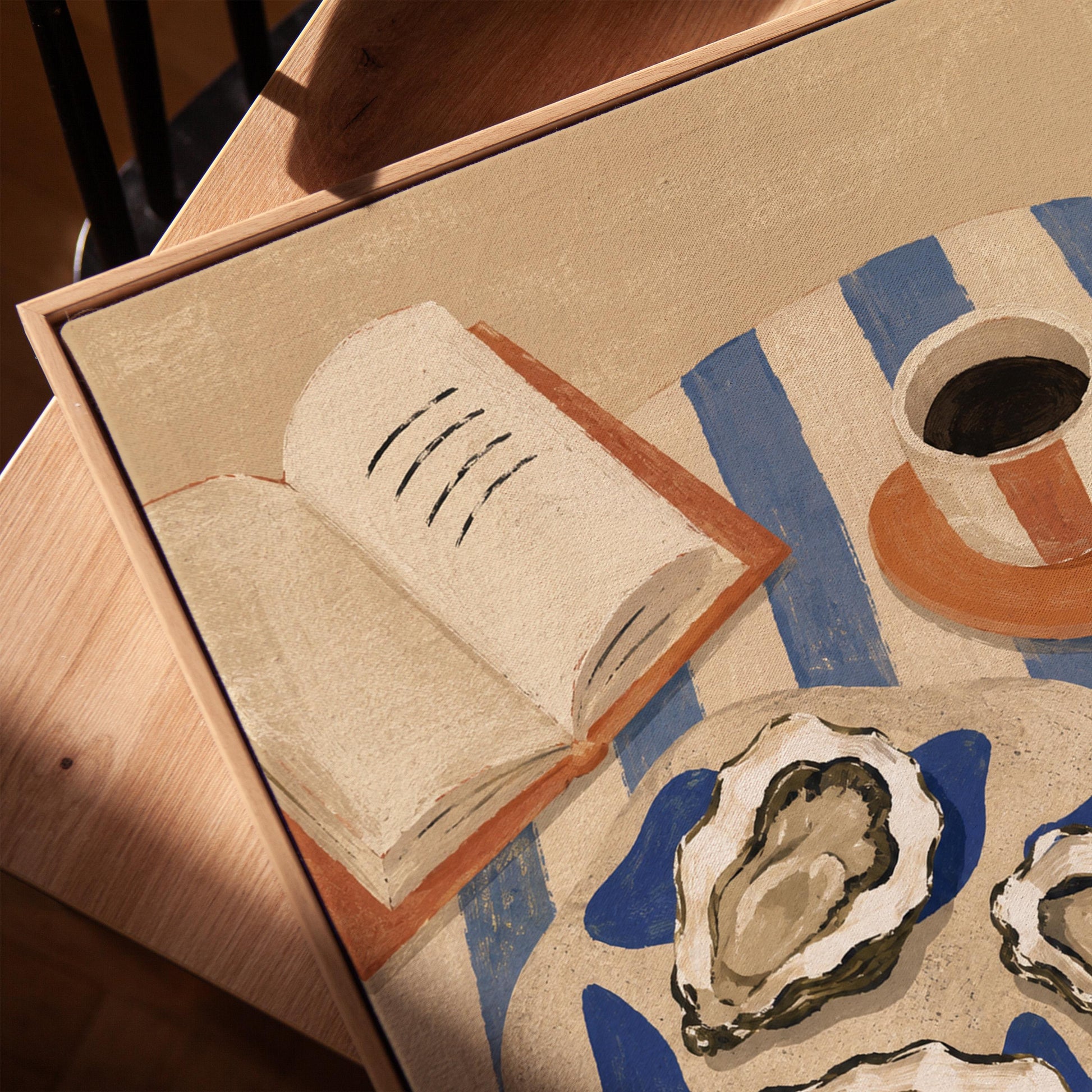 Plate of oysters with espresso and an open book on a striped cloth, canvas print in a warm, minimally styled interior