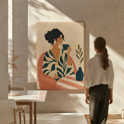Woman in a leaf print robe drinking from a teal cup beside a vase, canvas print on a quiet wall in a considered interior