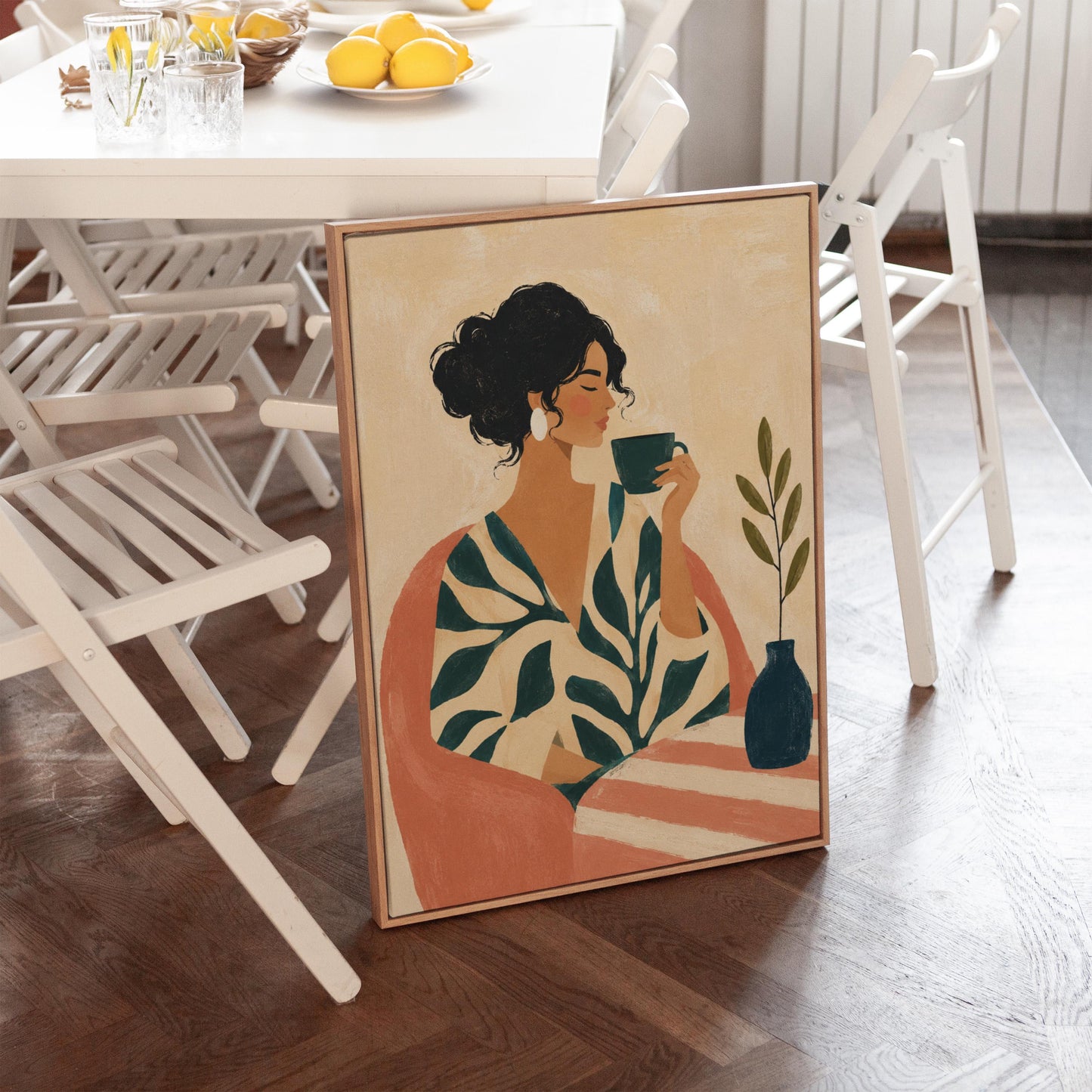 Woman in a leaf print robe drinking from a teal cup beside a vase, canvas print shown in a sunlit, contemporary room