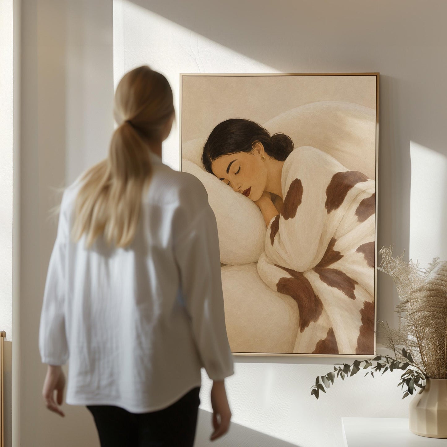 Woman asleep on a pillow under a cream blanket with brown markings, canvas print styled against a soft white wall