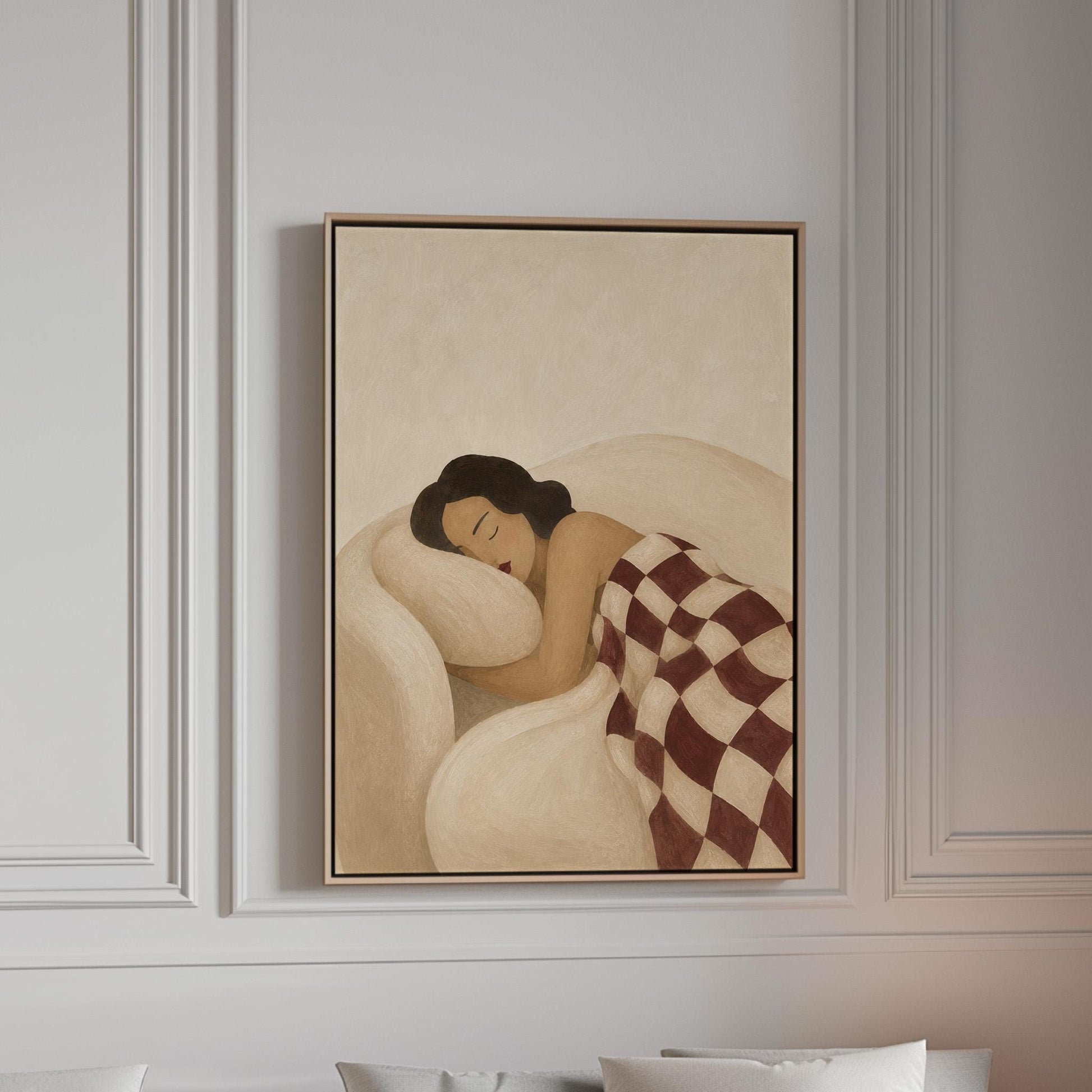 Woman sleeping under a burgundy and cream checkerboard blanket, canvas print in a bright room with natural daylight