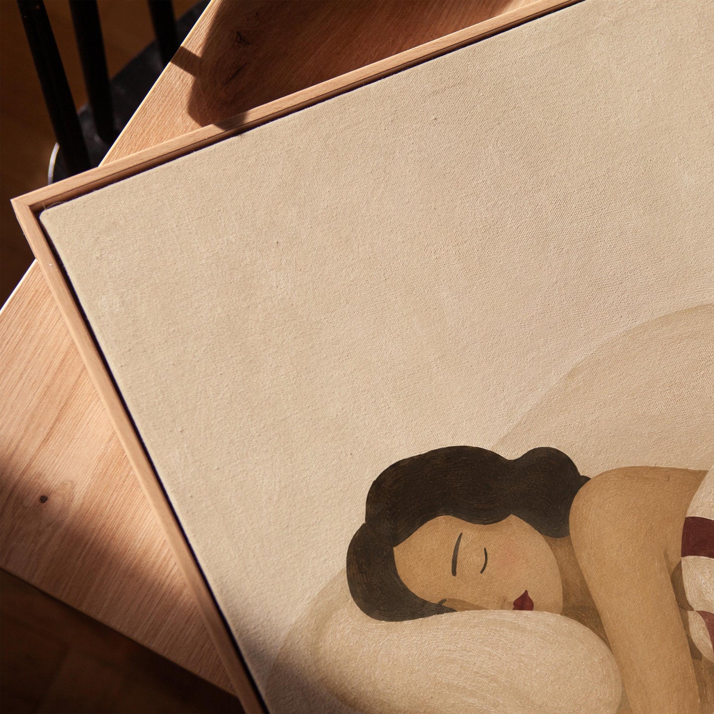 Woman sleeping under a burgundy and cream checkerboard blanket, canvas print in a warm, minimally styled interior