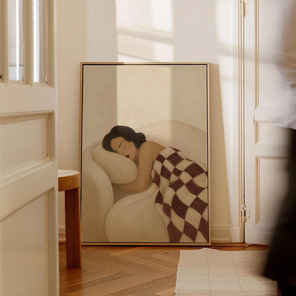 Woman sleeping under a burgundy and cream checkerboard blanket, canvas print displayed on a neutral wall in a styled interior