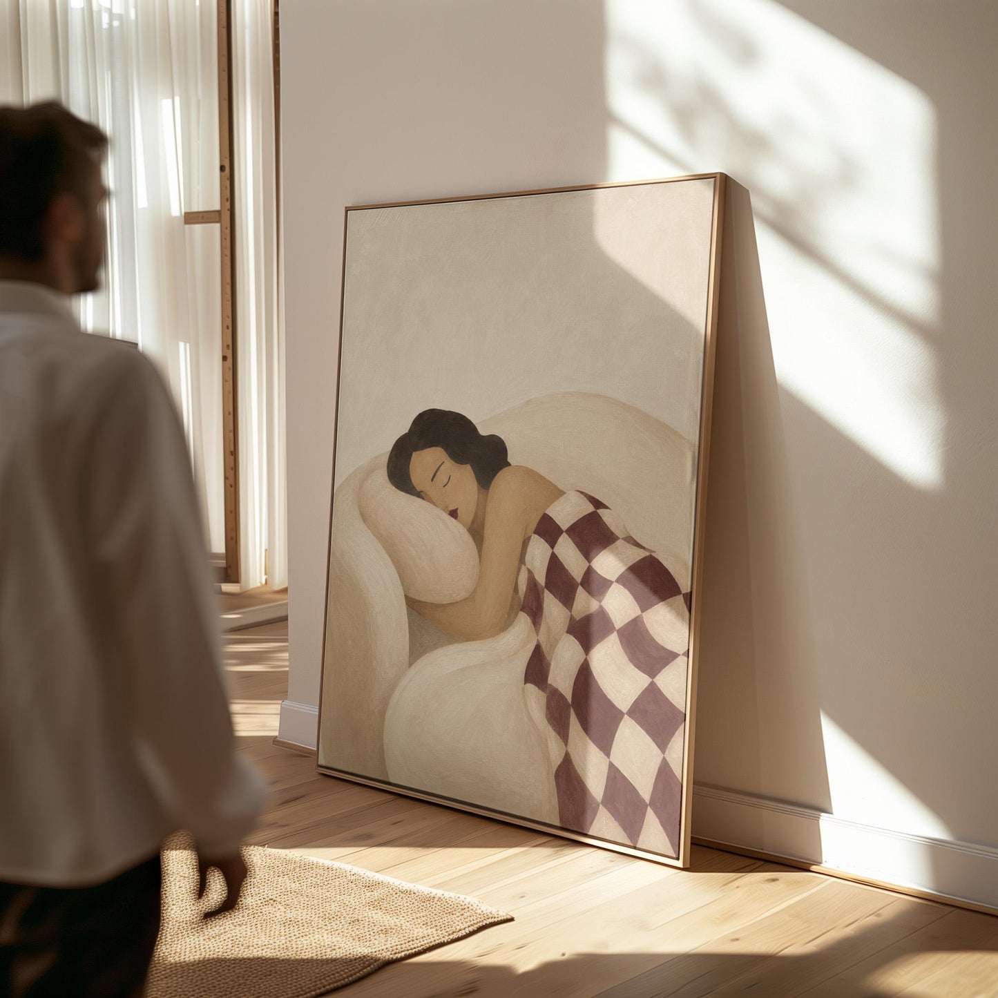 Woman sleeping under a burgundy and cream checkerboard blanket, canvas wall art presented in a light, minimal room