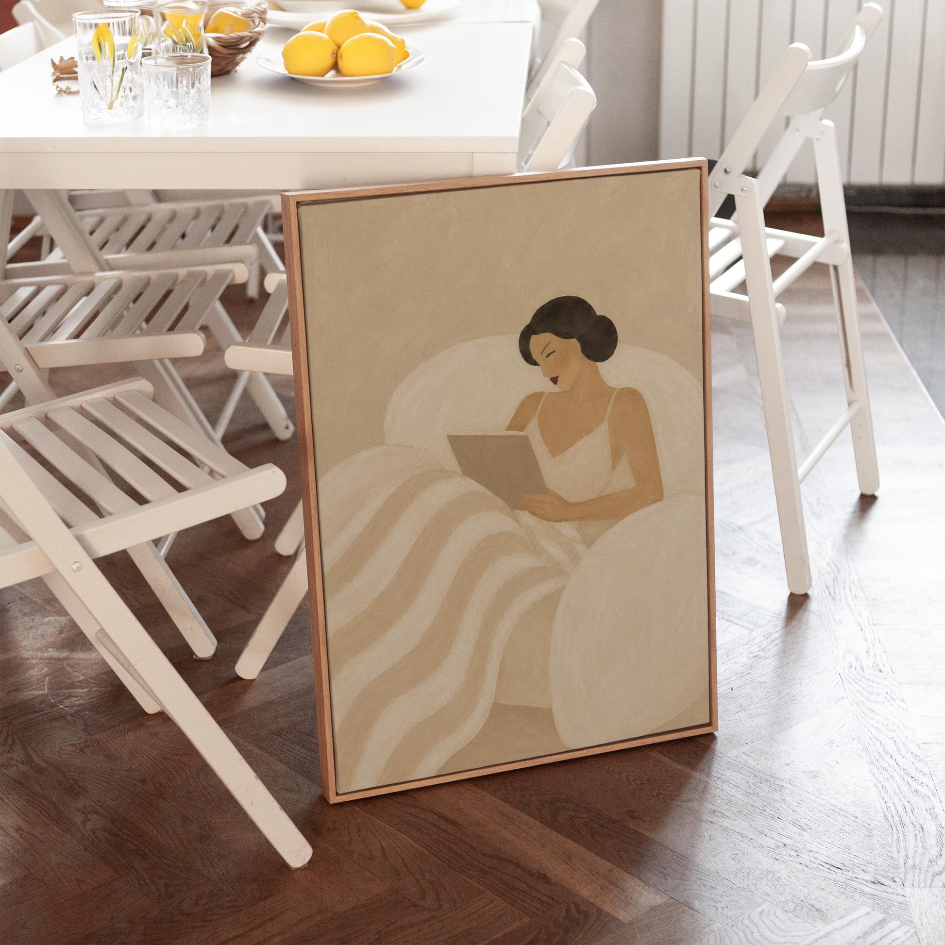 Woman in a white slip sitting up in bed reading in morning light, canvas print styled against a soft white wall