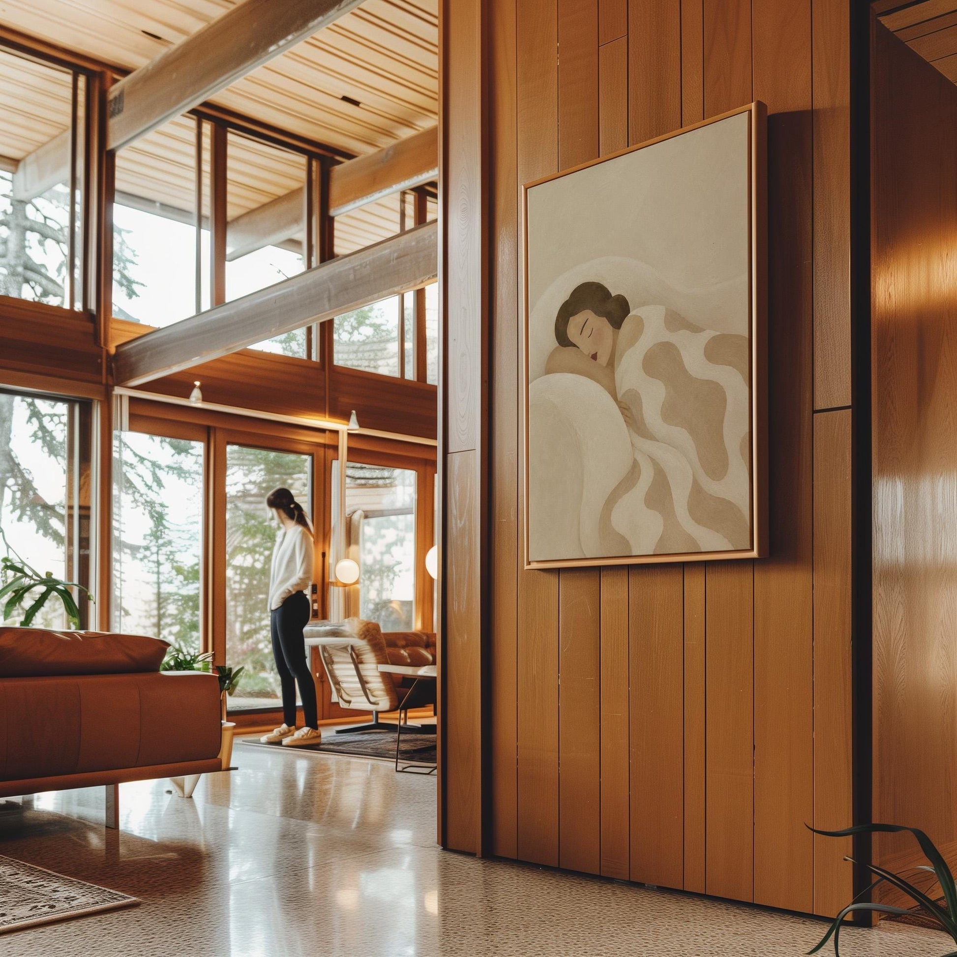 Woman sleeping under a cream blanket with soft camel cloud shapes, canvas wall art seen in a warm interior with natural light