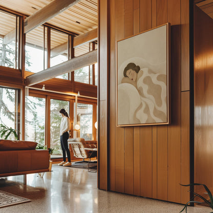 Woman sleeping under a cream blanket with soft camel cloud shapes, canvas wall art seen in a warm interior with natural light