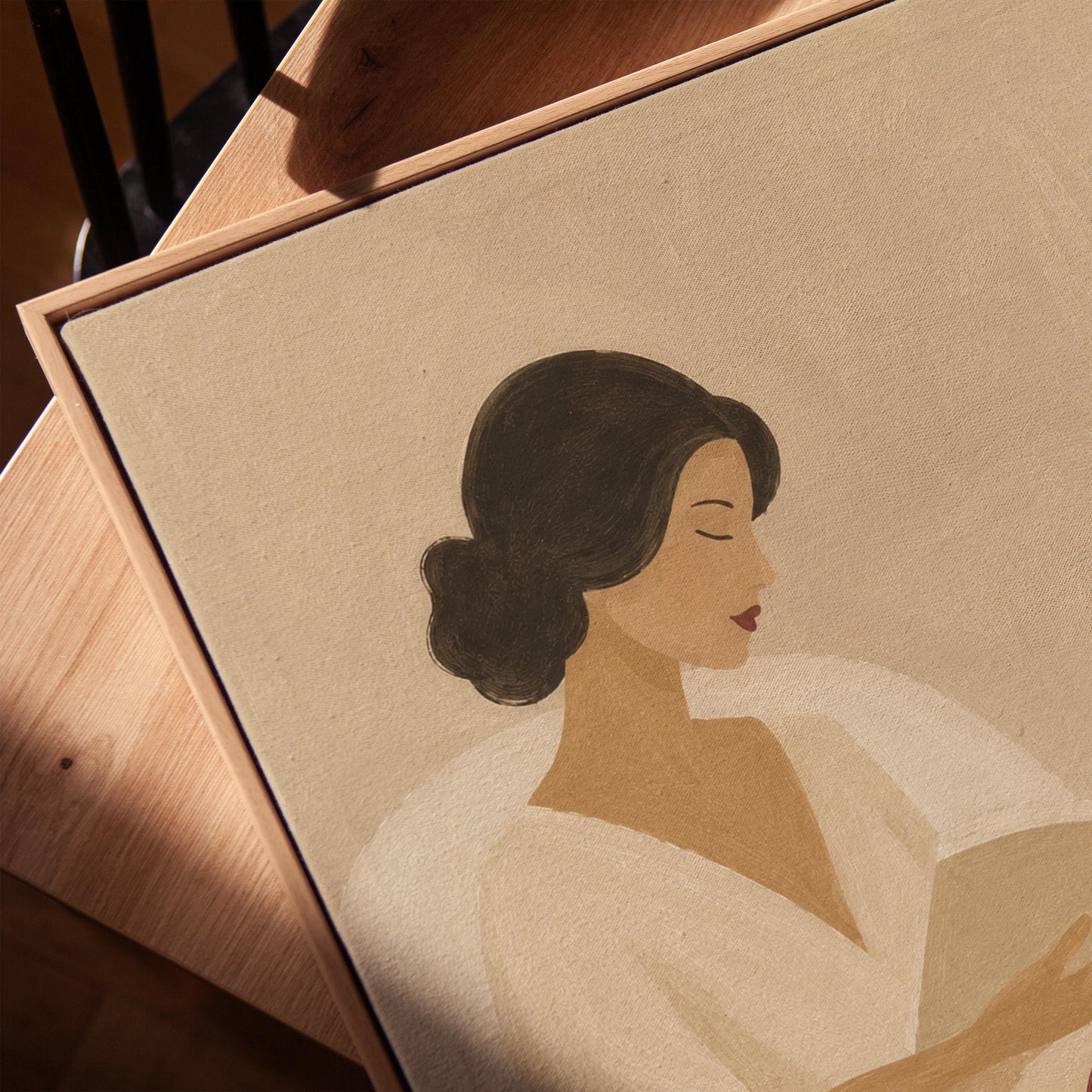 Woman in a white robe reading in an armchair with a black coffee, canvas print in a warm, minimally styled interior