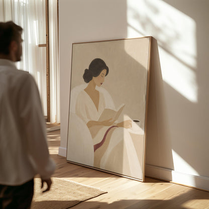 Woman in a white robe reading in an armchair with a black coffee, canvas wall art hanging in a calm, modern living space