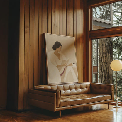 Woman in a white robe reading in an armchair with a black coffee, canvas wall art on a quiet wall in a considered interior