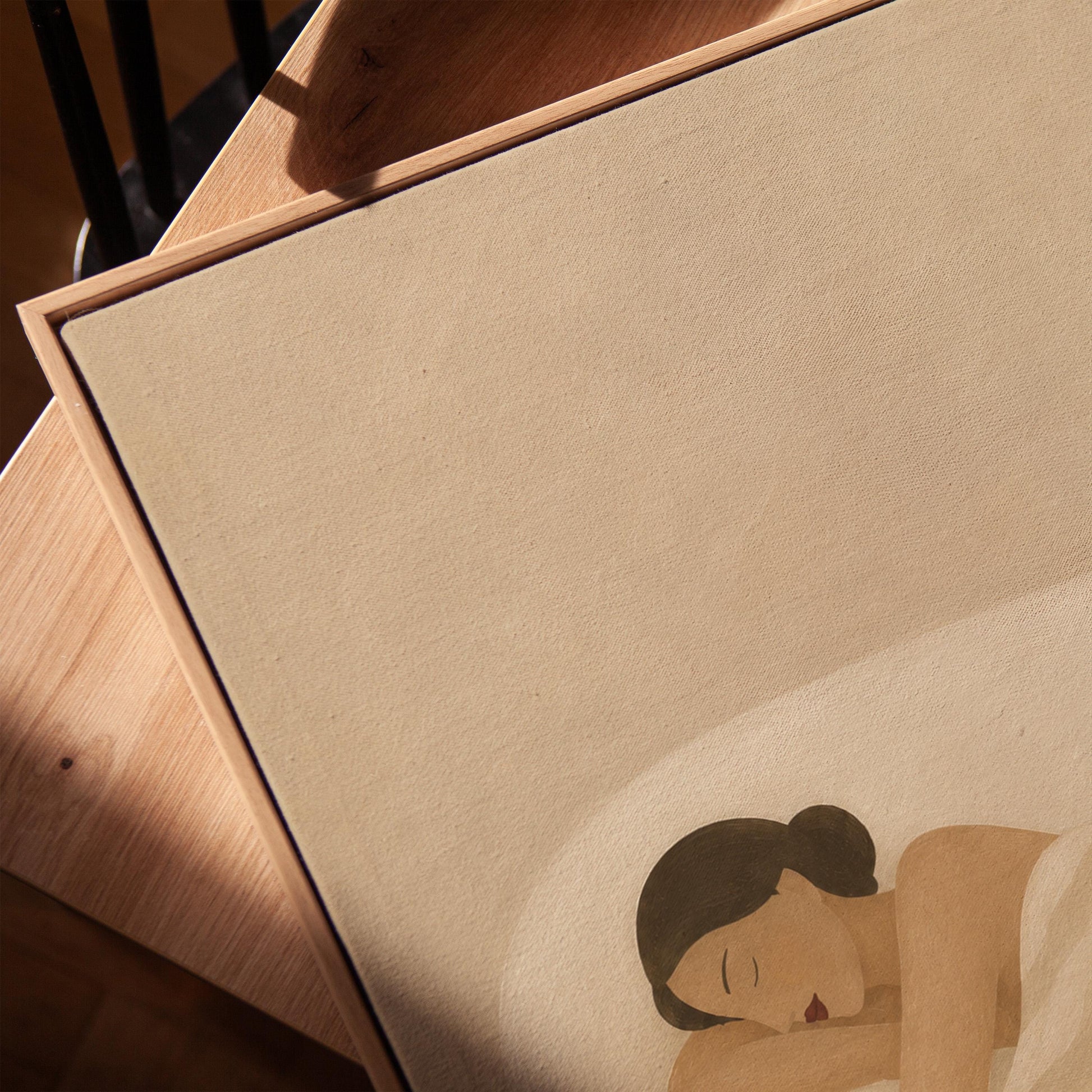 Woman sleeping with hands under her cheek beneath a soft striped quilt, canvas print in a warm, minimally styled interior