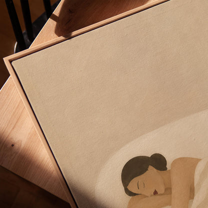 Woman sleeping with hands under her cheek beneath a soft striped quilt, canvas print in a warm, minimally styled interior