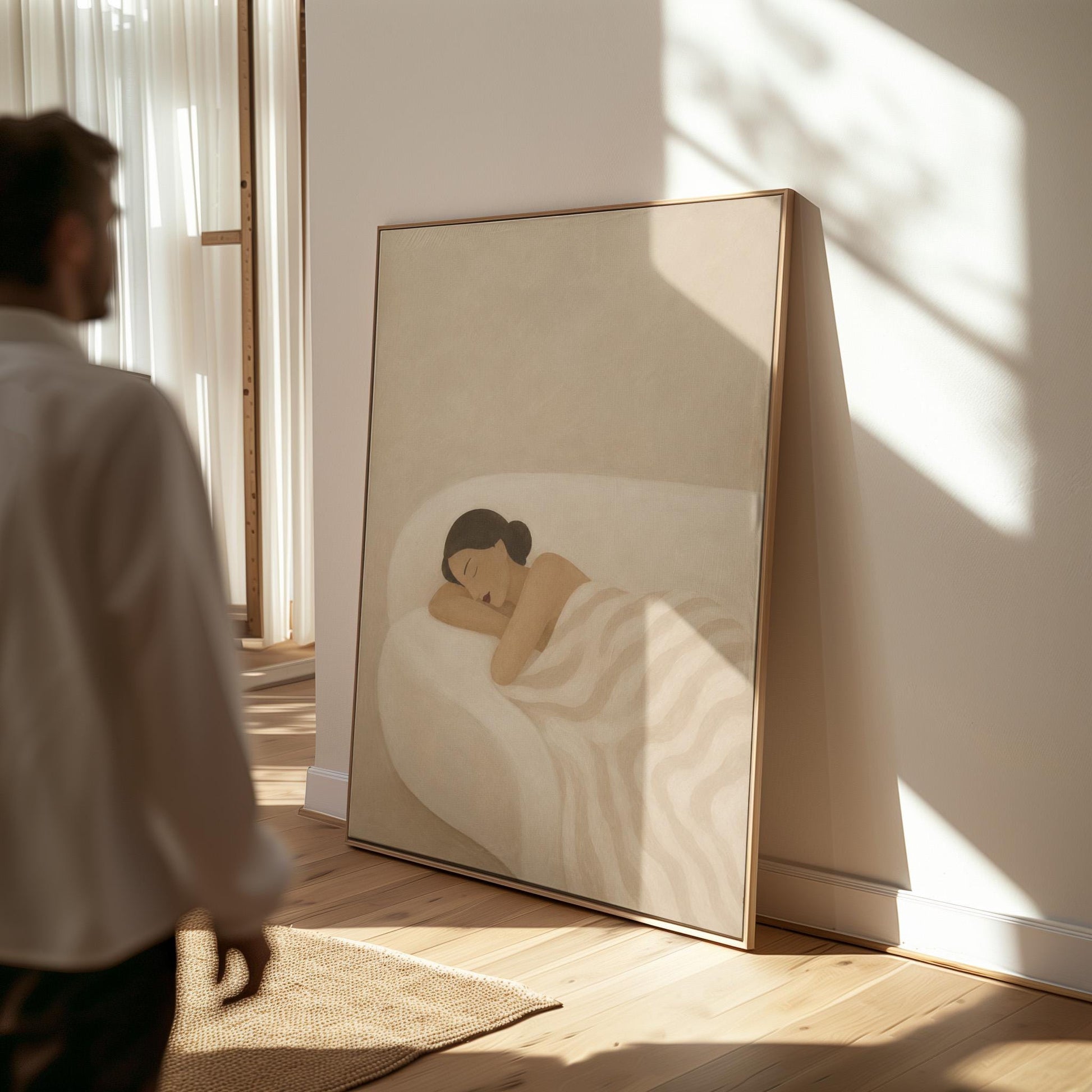 Woman sleeping with hands under her cheek beneath a soft striped quilt, canvas wall art presented in a light, minimal room