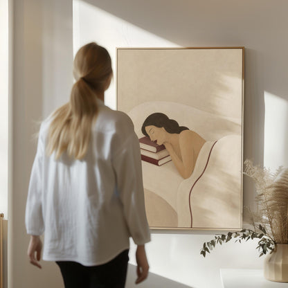 Woman resting her cheek on a stack of cream and burgundy books, canvas print hanging in a calm, modern living space