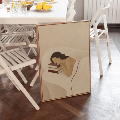 Woman resting her cheek on a stack of cream and burgundy books, canvas wall art styled against a soft white wall