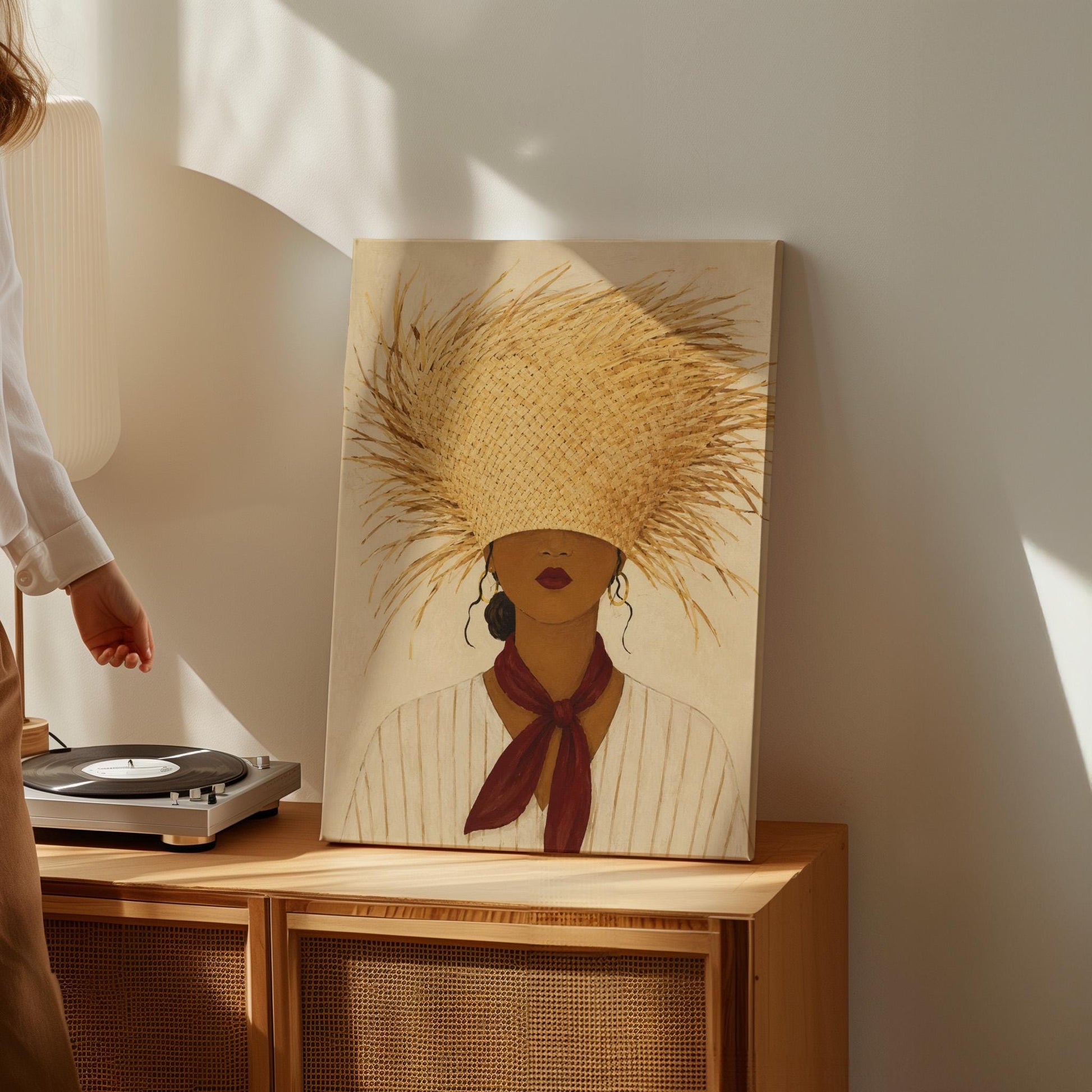 Woman in a huge fringed straw hat with a red scarf and striped shirt, canvas wall art on a quiet wall in a considered interior