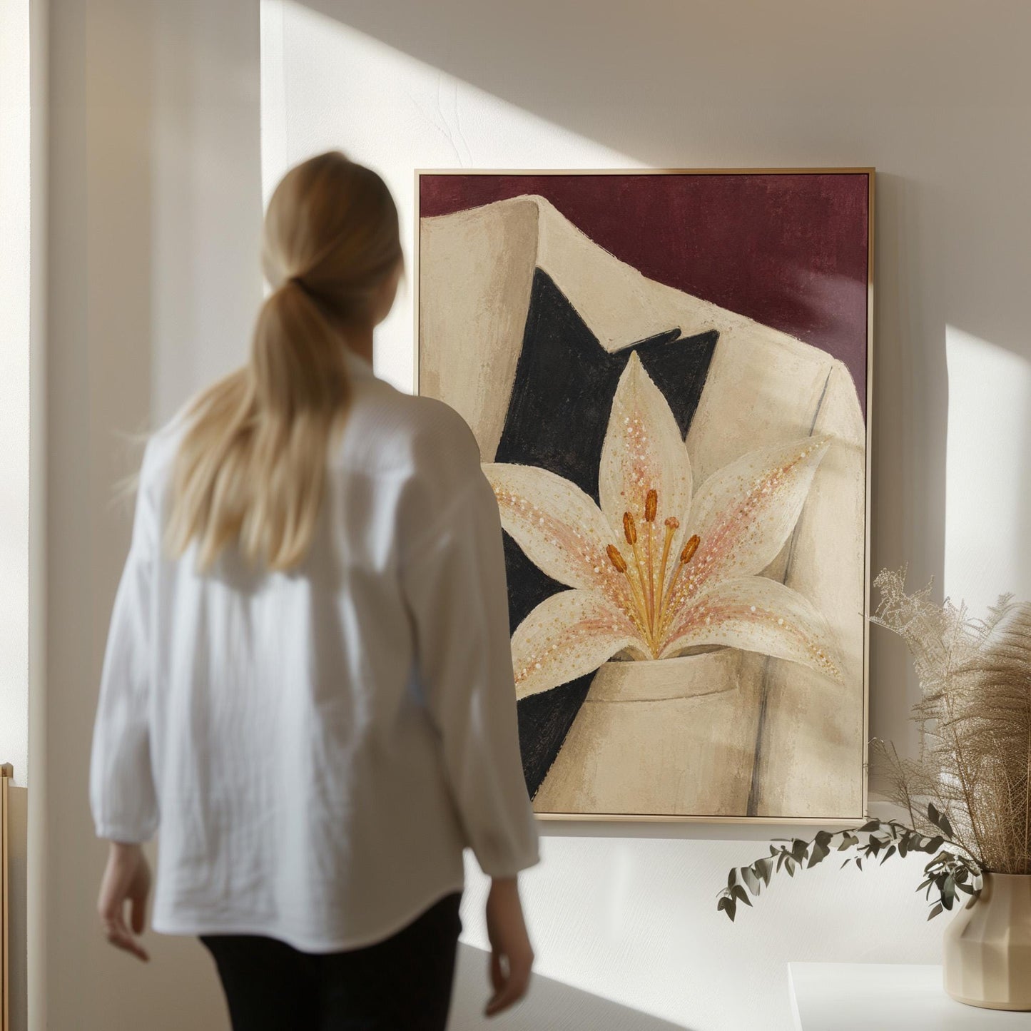 White pearl flecked lily on a cream tuxedo lapel over deep burgundy, canvas wall art presented in a light, minimal room