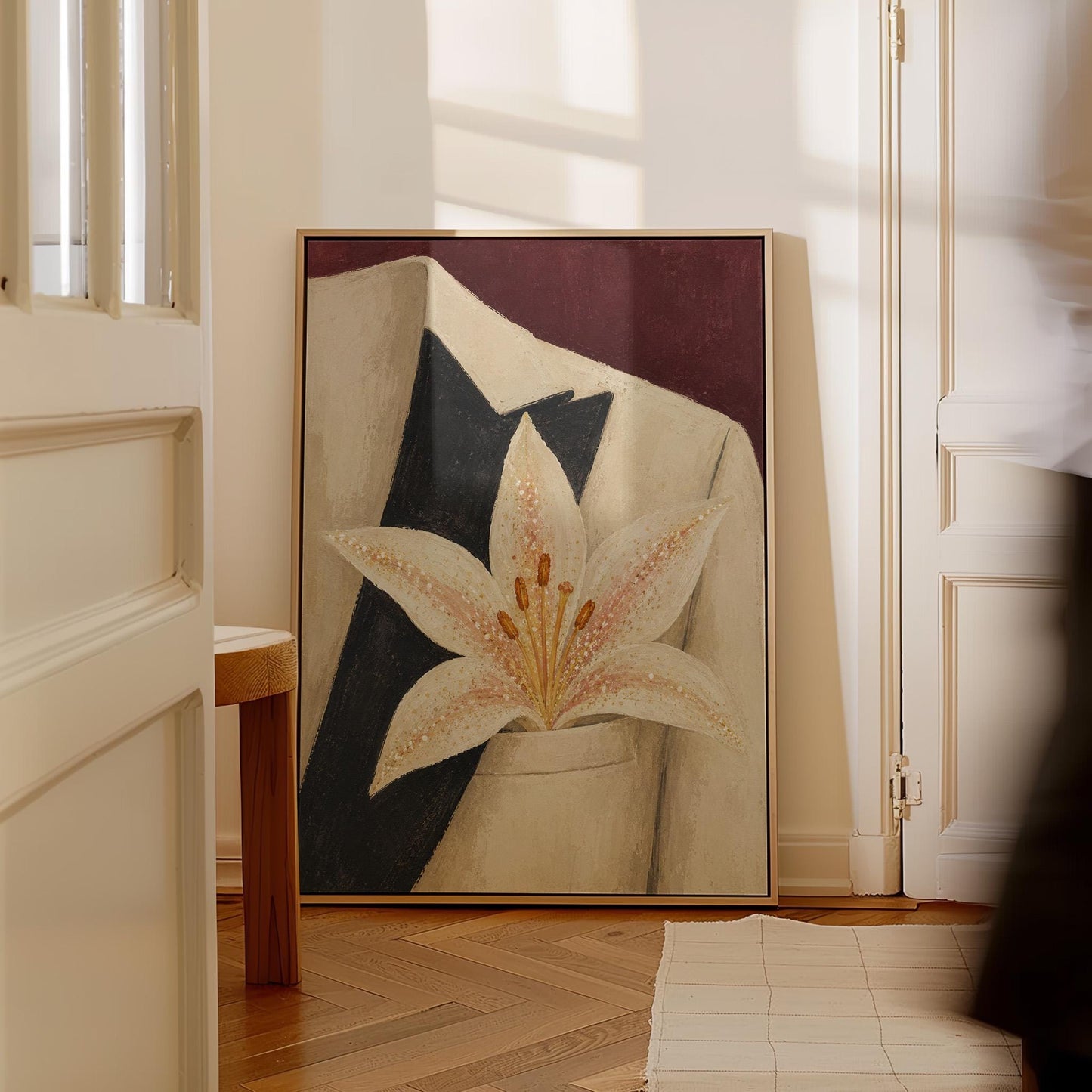 White pearl flecked lily on a cream tuxedo lapel over deep burgundy, canvas wall art on a quiet wall in a considered interior