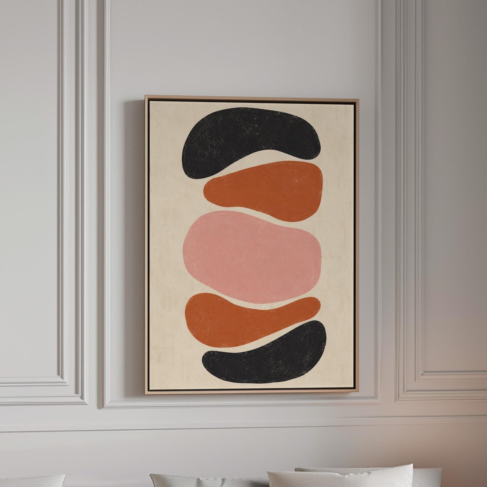 Five stacked pebble shapes in charcoal rust and blush on cream, canvas print in a bright room with natural daylight