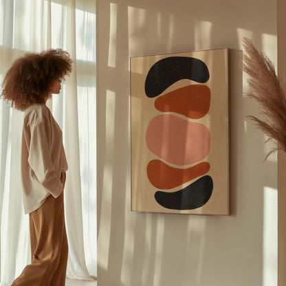 Five stacked pebble shapes in charcoal rust and blush on cream, canvas wall art seen in a warm interior with natural light